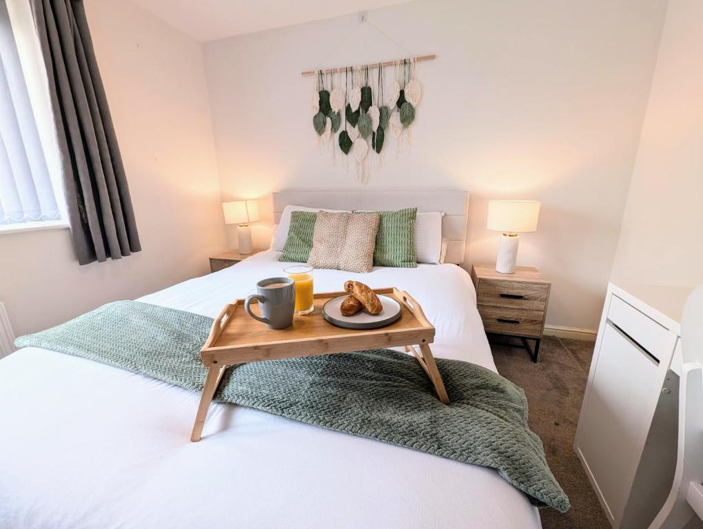 una camera da letto con un letto con un vassoio di cibo sopra di Steps from O2 Apollo, Ox road a Manchester