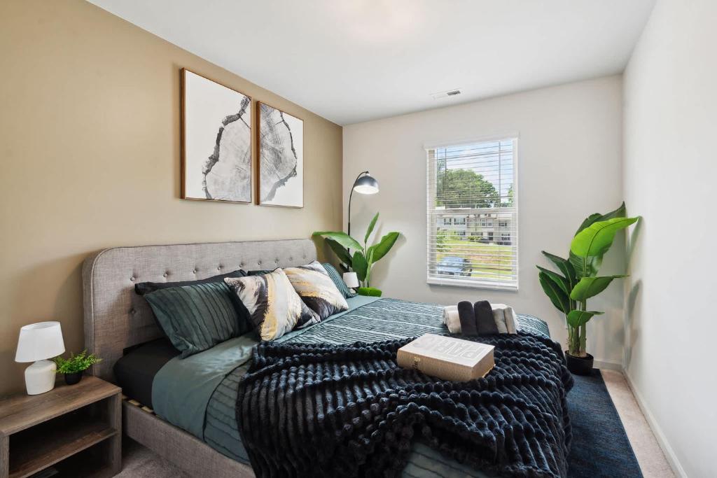 un dormitorio con una cama y un sofá en Upscale King 3BR Townhouse Mins to Cary & NC State, en Raleigh
