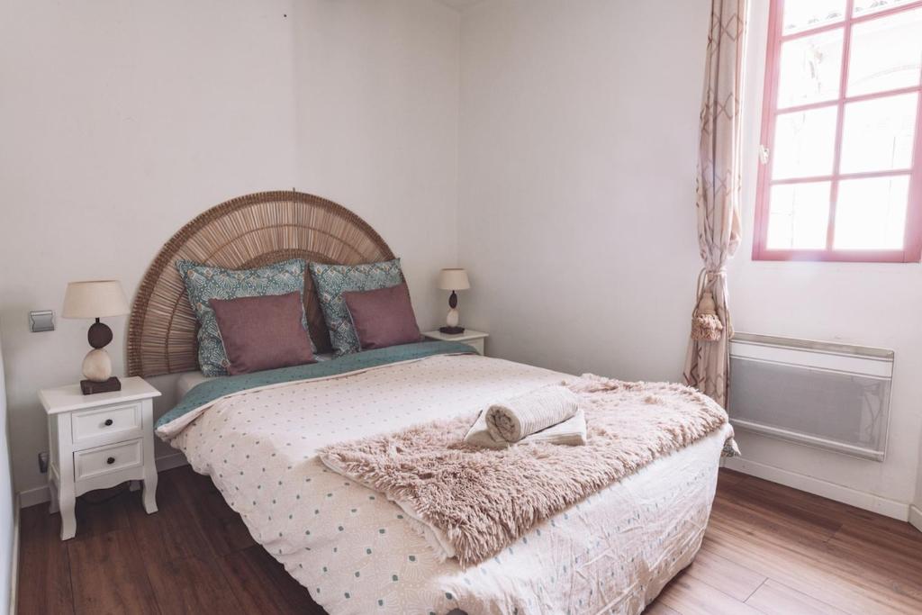 une chambre avec un grand lit avec une tête de lit en bois dans l'établissement Le Provençal Apartment, Cozy, Quiet, Warm, à La Garde-Freinet