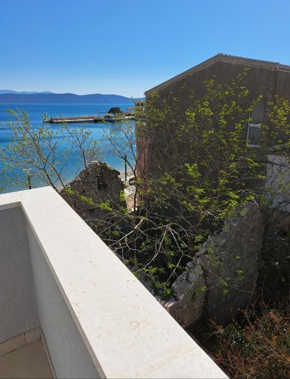 a retaining wall next to a building and the ocean at Apartman Matea in Igrane