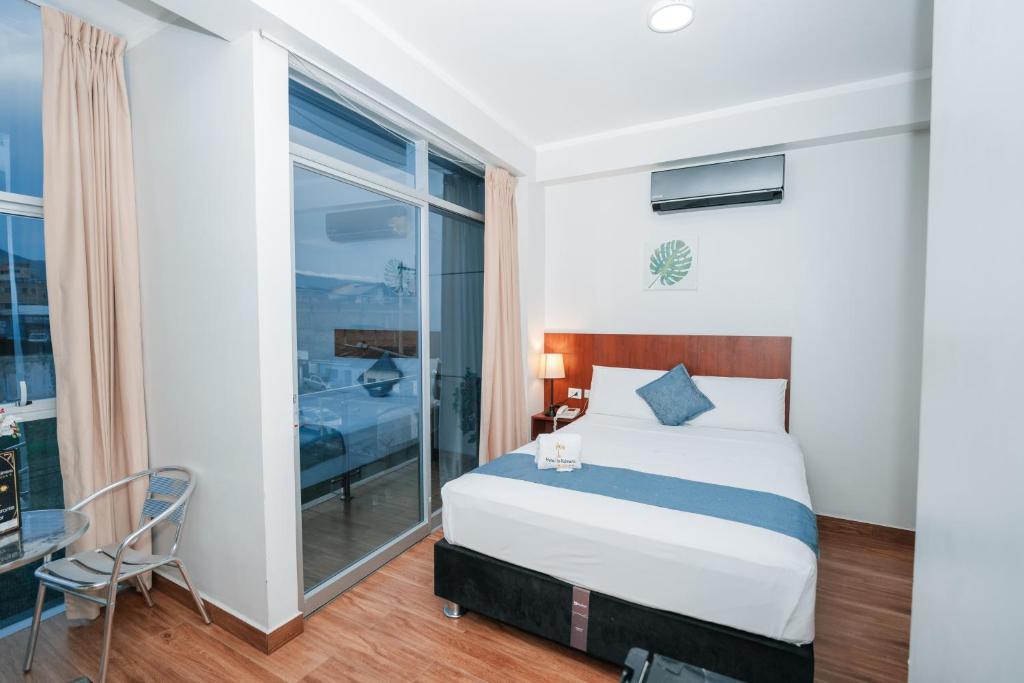 a bedroom with a bed and a large window at HOTEL LA PALMERA DE ORO in Tarapoto
