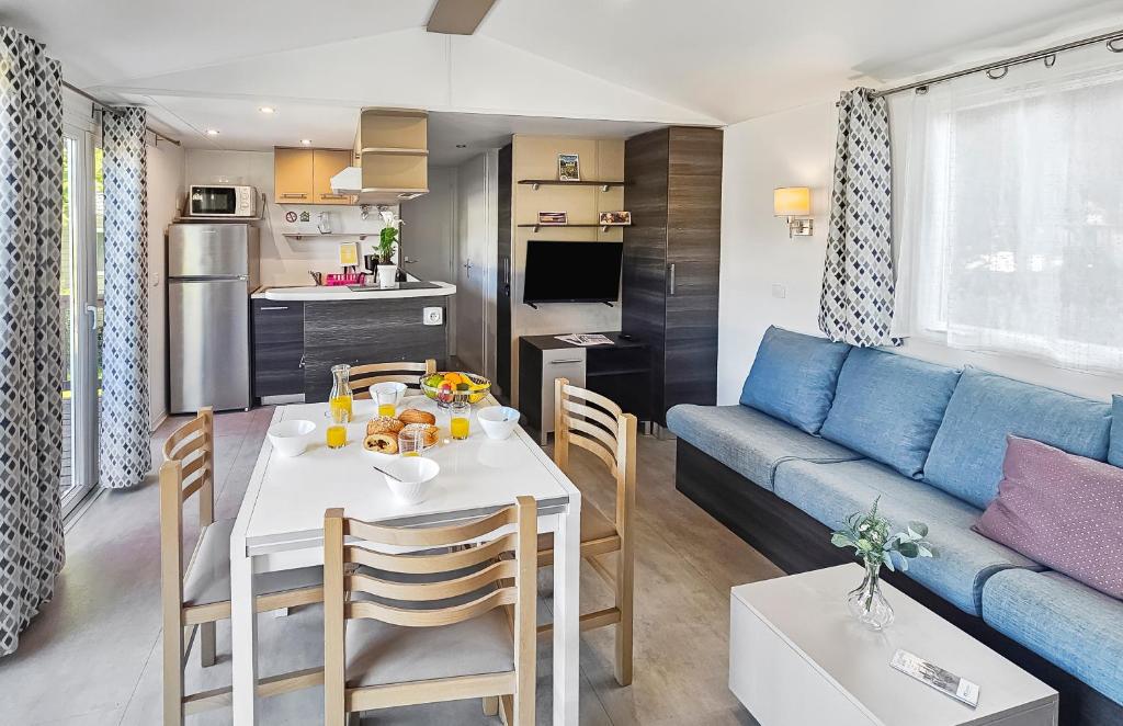 un salon avec une table et un canapé bleu dans l'établissement Nomadys, à Litteau