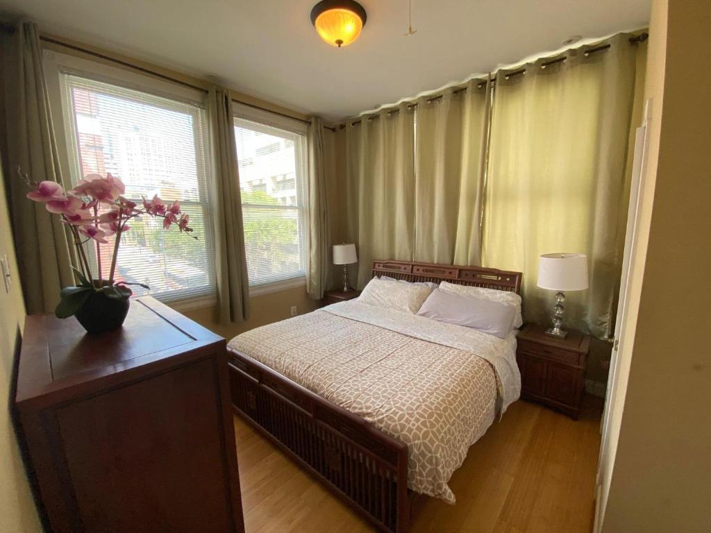 a bedroom with a bed with a vase of flowers on it at 501 Cozy Apartment near Baltimore Inner Harbor!!! in Baltimore