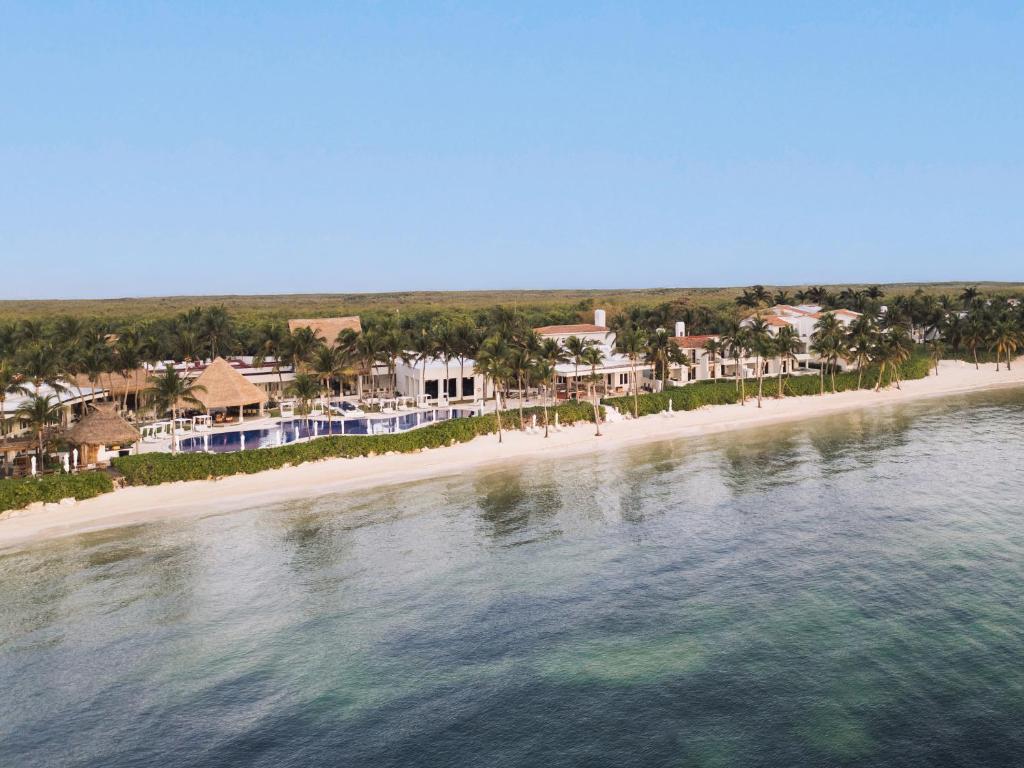 an aerial view of a beach with houses and the water at Paraiso de la Bonita Adult All-Inclusive, a Luxury Collection Resort in Puerto Morelos