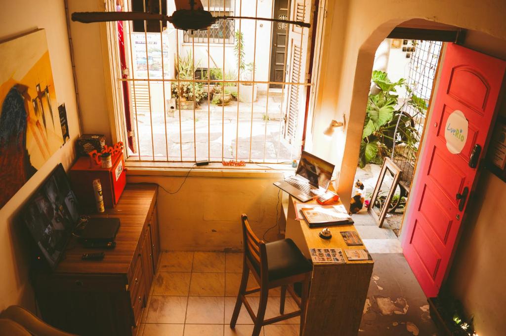 a room with a desk and a red door and a window at LiveRio Hostel Ipanema in Rio de Janeiro