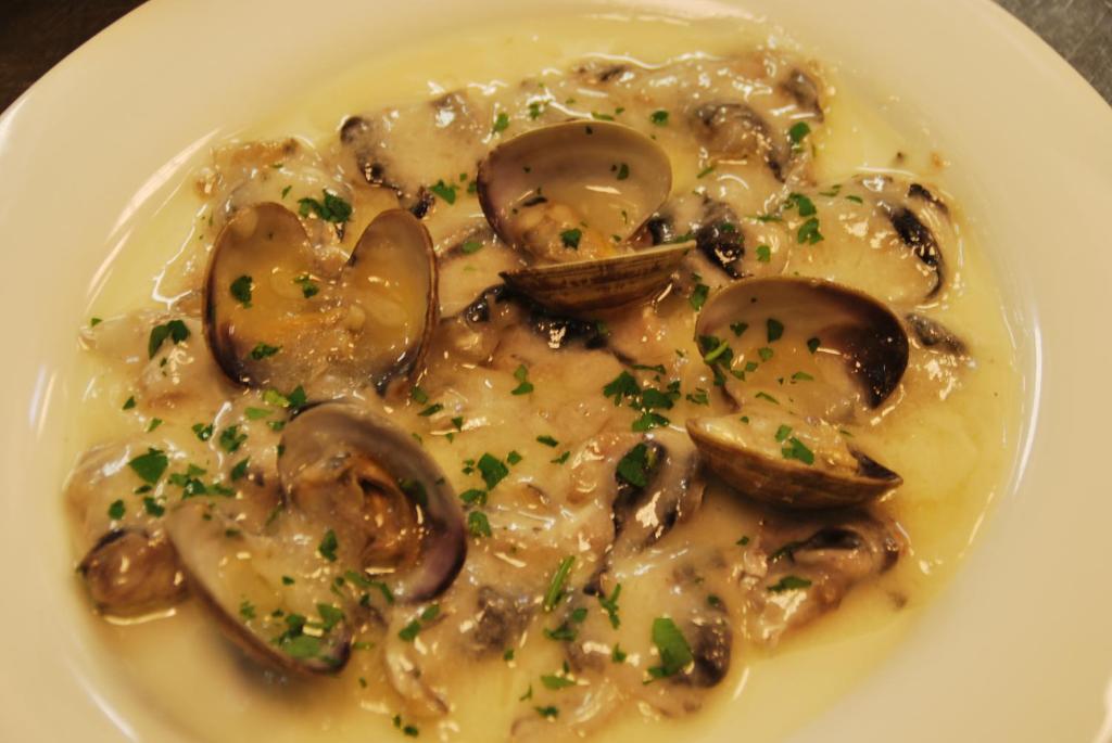 a plate of food with mushrooms in a sauce at Aparthotel Meseguer in Alcañiz