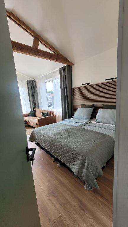 a bedroom with two beds and a couch at Dulce Tierra - appartement in Zoutelande