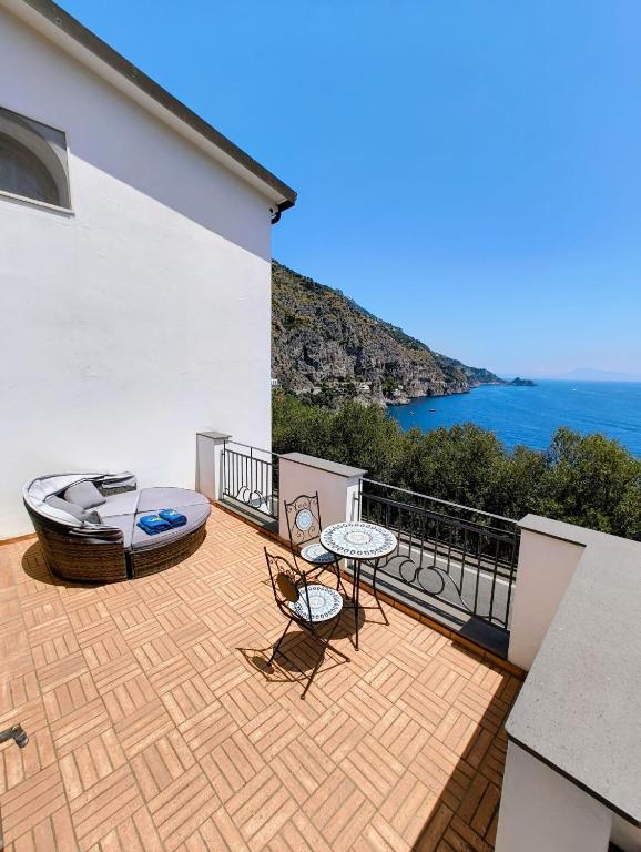 a balcony with a table and chairs and the ocean at HOLIDAY double in Praiano