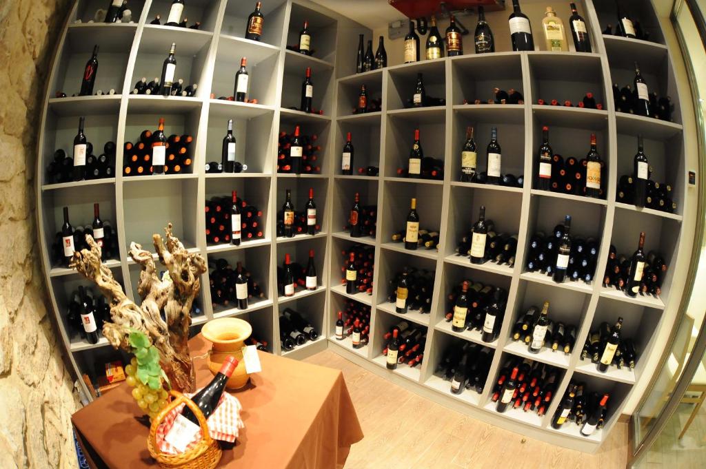 a shelf filled with lots of bottles of wine at Aparthotel Meseguer in Alcañiz