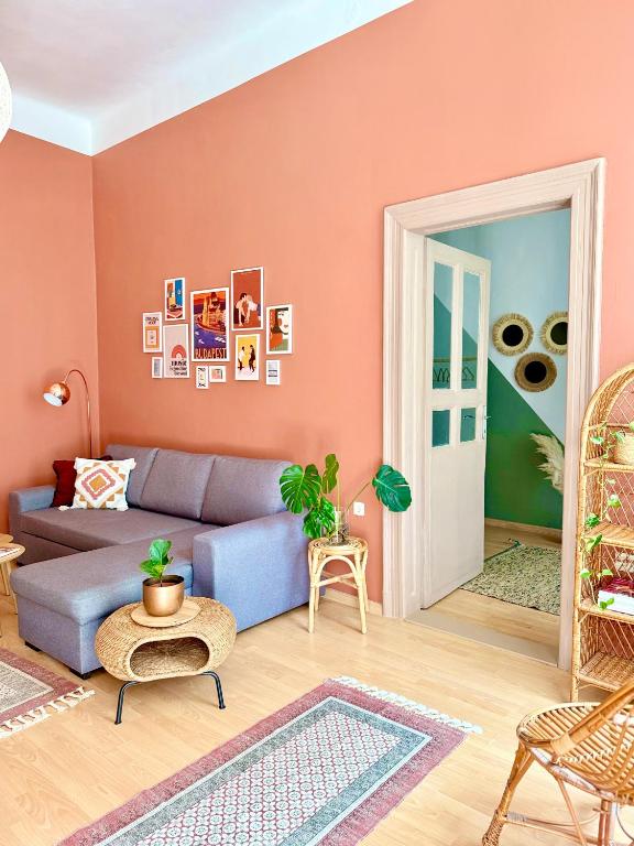 布达佩斯Churri Downtown - with Garage的客厅设有蓝色的沙发和粉红色的墙壁。