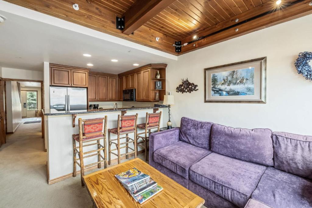 a living room with a purple couch and a kitchen at Landmark Vail - Charming Condo for 8 with Resort-style Amenities in Vail