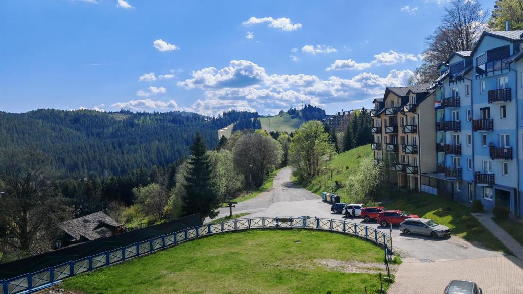 a road in the mountains with cars parked on the road at Apartmán EveRest Donovaly in Donovaly