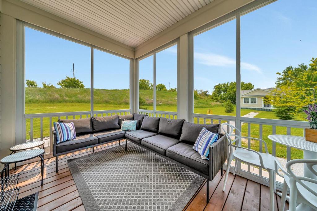 a screened in porch with a couch and a table at The Rushes - 47 Butternut in Cherry Valley