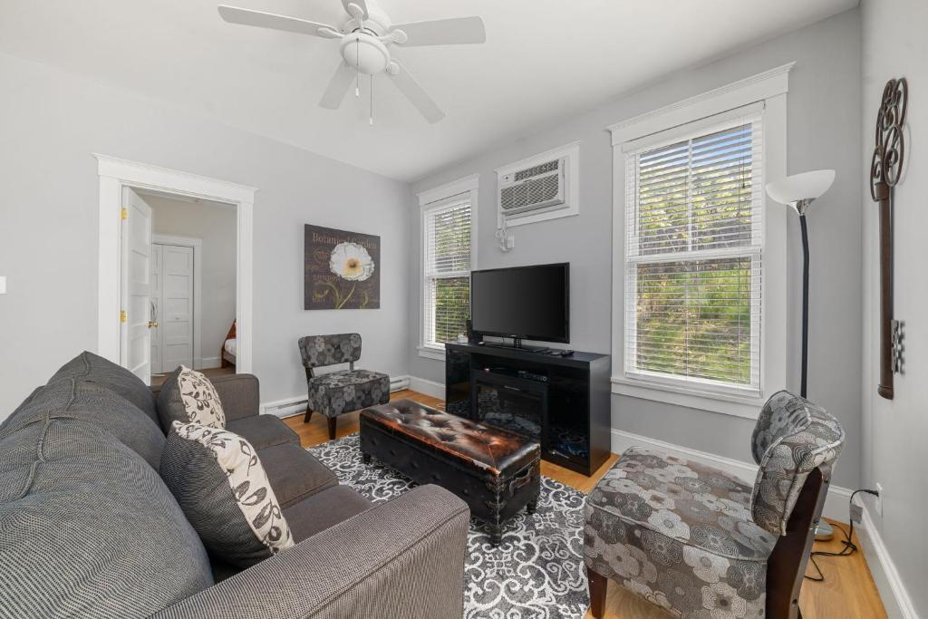 a living room with a couch and a flat screen tv at The Cattail - 26 Meadowview in Cherry Valley