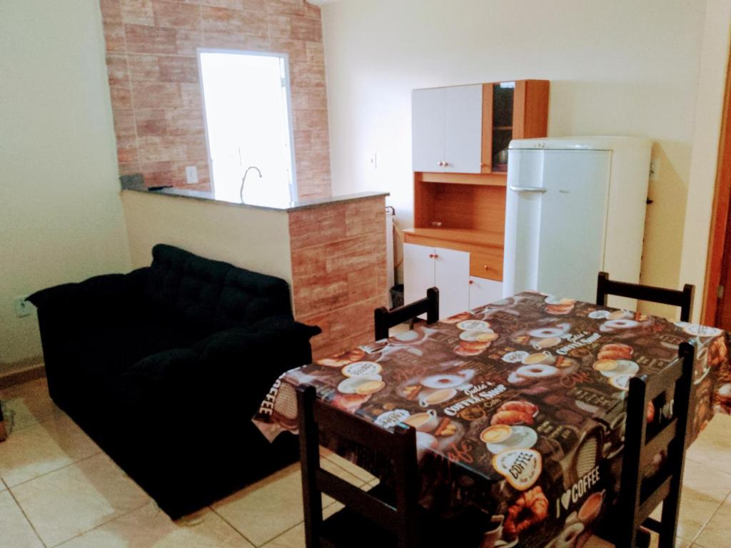 a living room with a table and a kitchen at Bem Estar5 in Aparecida