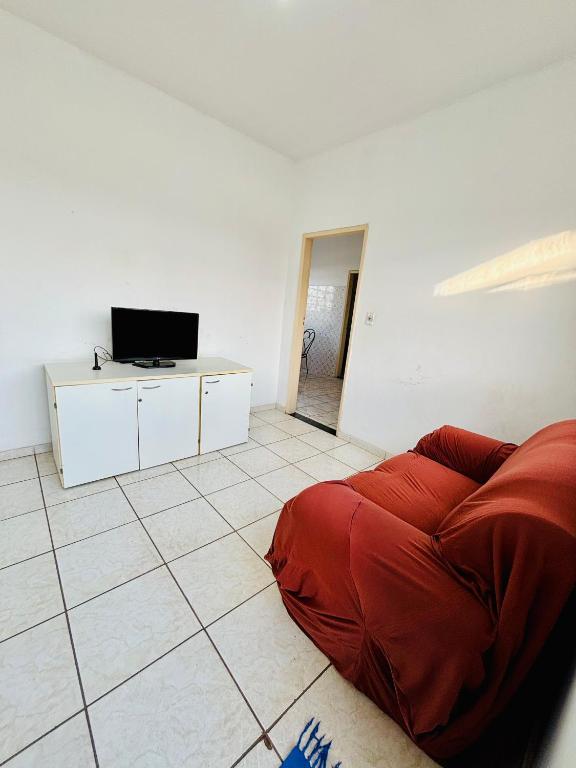 a living room with a red bed and a tv at Apartamento mobiliado em Contagem - 2 quartos in Contagem