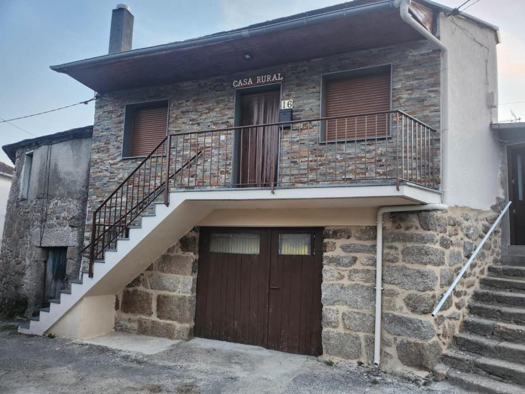 an old brick house with stairs and a door at Casa rural in Ourense