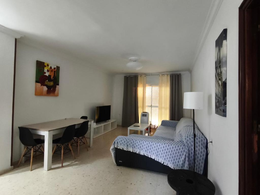 a bedroom with a bed and a table and a desk at Piso El Comienzo in Puerto Real