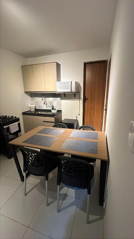 a kitchen with a table and chairs in a room at Apto inteiro no centro de caruaru para 2 pessoas in Caruaru