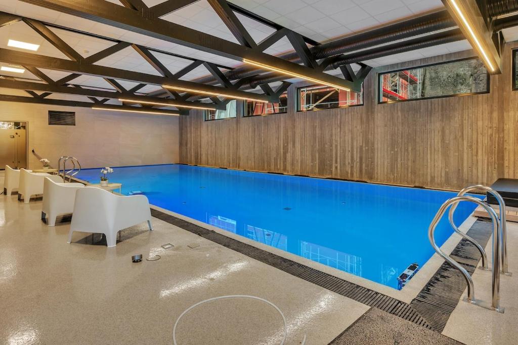 Una gran piscina con agua azul en un edificio. en Åros Modern Apartment, en Kristiansand