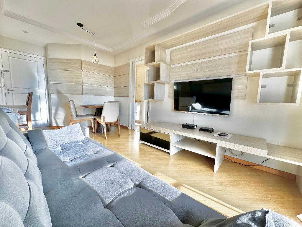 a living room with a couch and a desk with a tv at Maison D Stan Moema with washing machine and daily cleaning in São Paulo