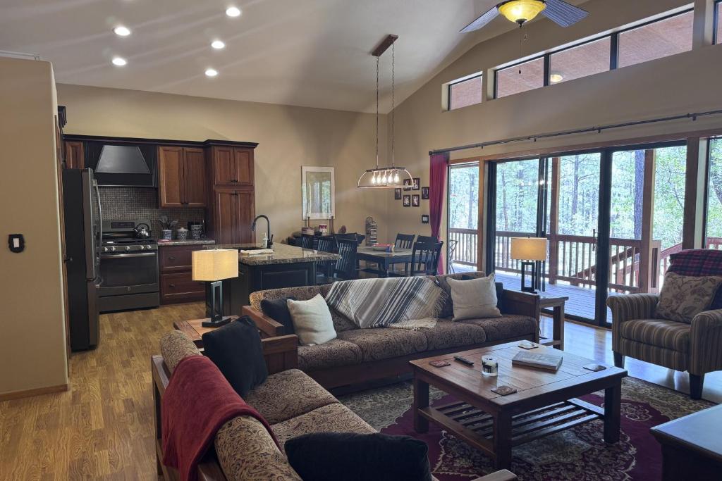 a living room with couches and a table and a kitchen at Elk Run Escape in Show Low