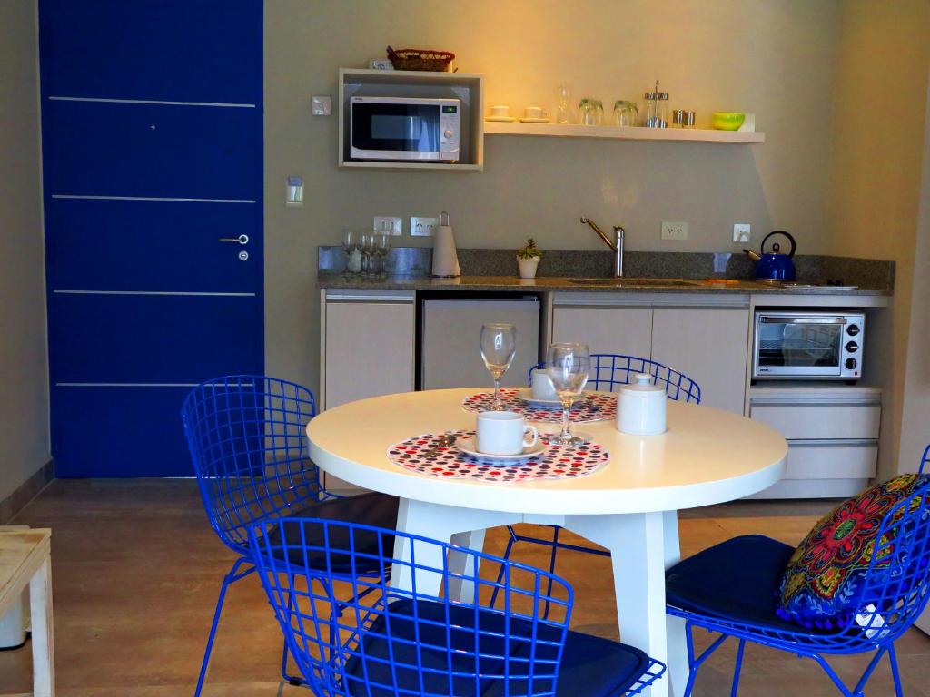 a kitchen with a table and chairs with wine glasses at Azar Departamentos Tandil in Tandil