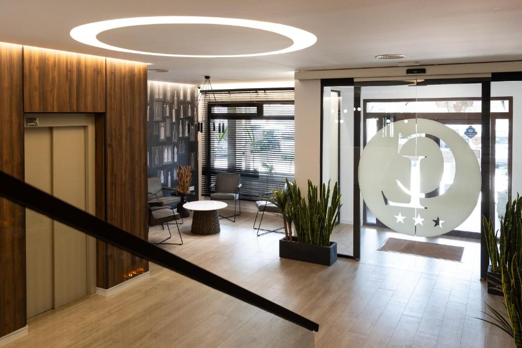 Un vestíbulo de oficinas con una escalera y un gran reloj. en Habitus Casa Lorenzo, en Villarrobledo