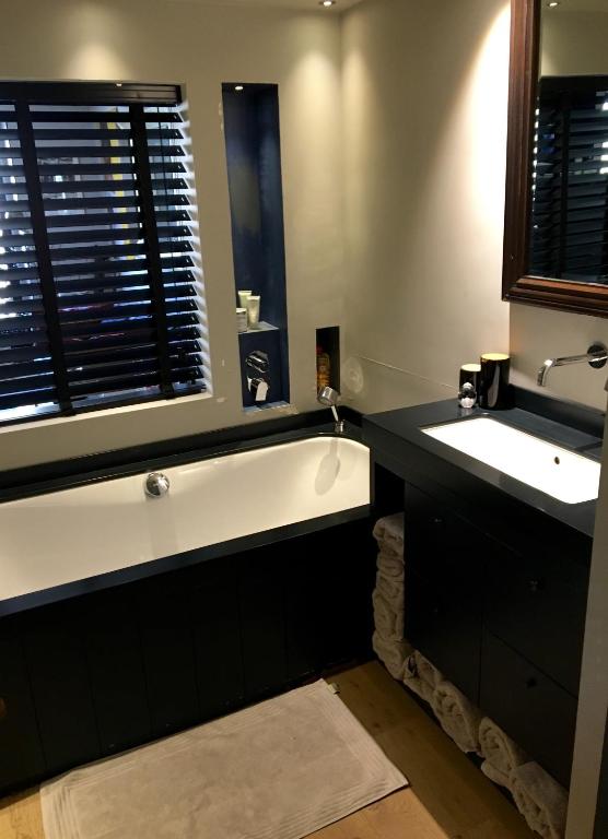 une salle de bain avec une baignoire, un lavabo et un miroir dans l'établissement Le Marais by Steph, à Paris