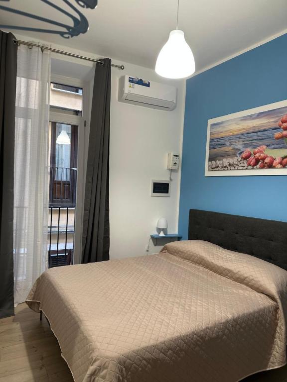 a bedroom with a bed and a painting on the wall at Orologio21-Soggiorna al teatro Massimo in Palermo