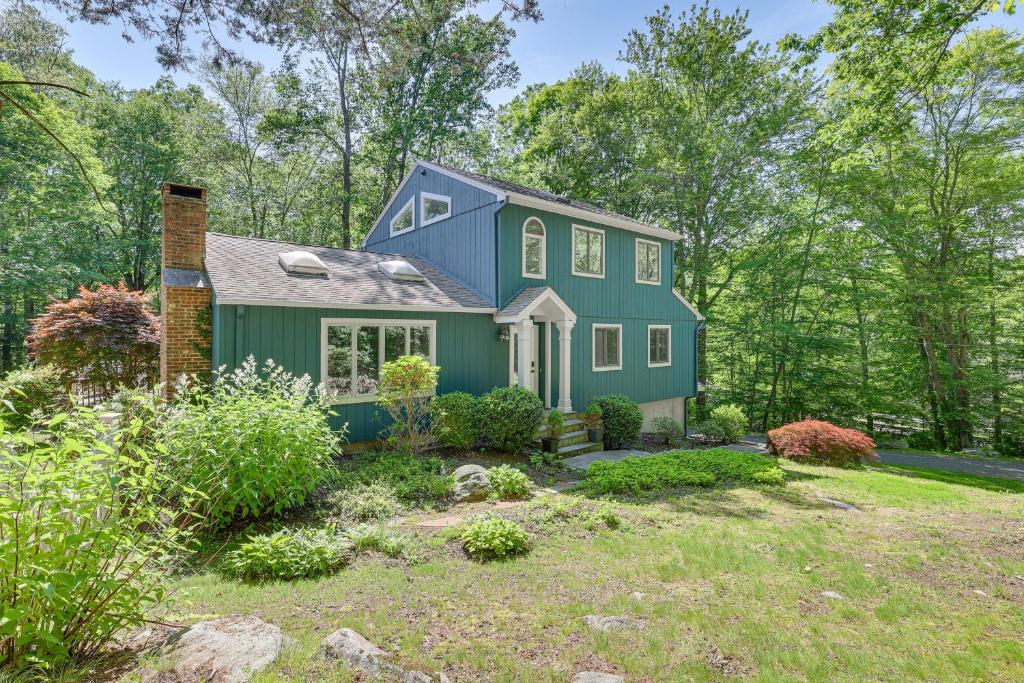 a blue house in the middle of a yard at Cozy Woodland Home! Ski and Hike Coastal Connecticut in Killingworth