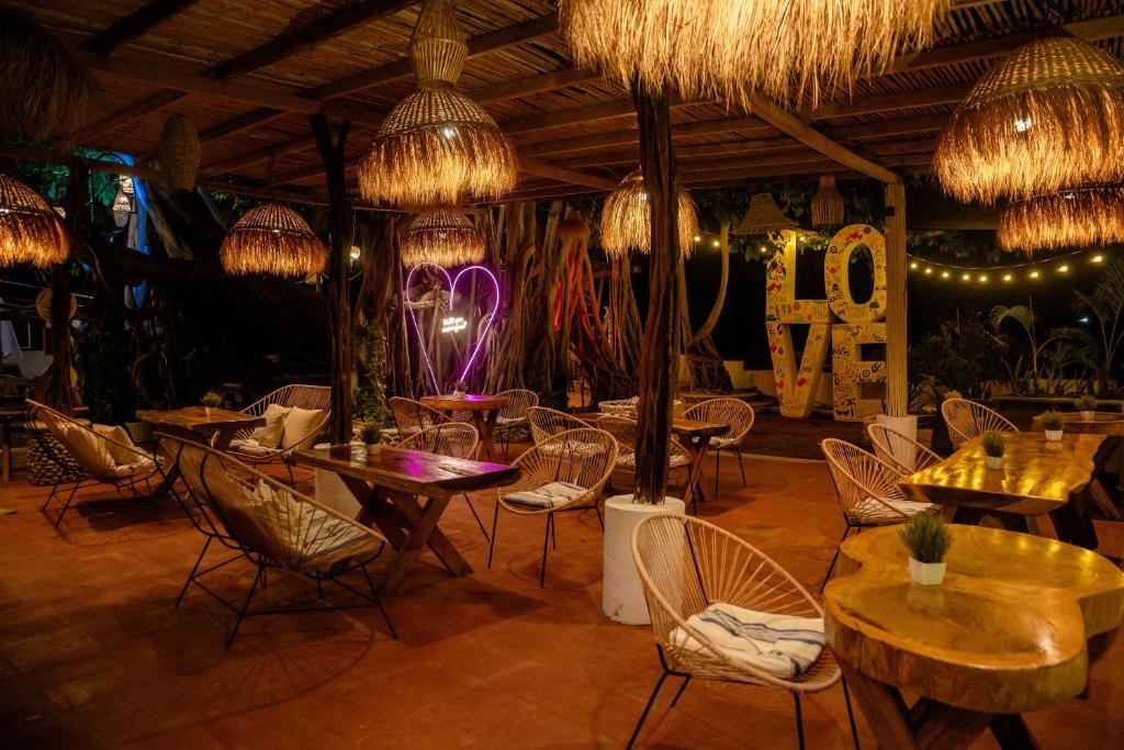 a restaurant with tables and chairs and chandeliers at Hotel Boutique Evana in Acapulco