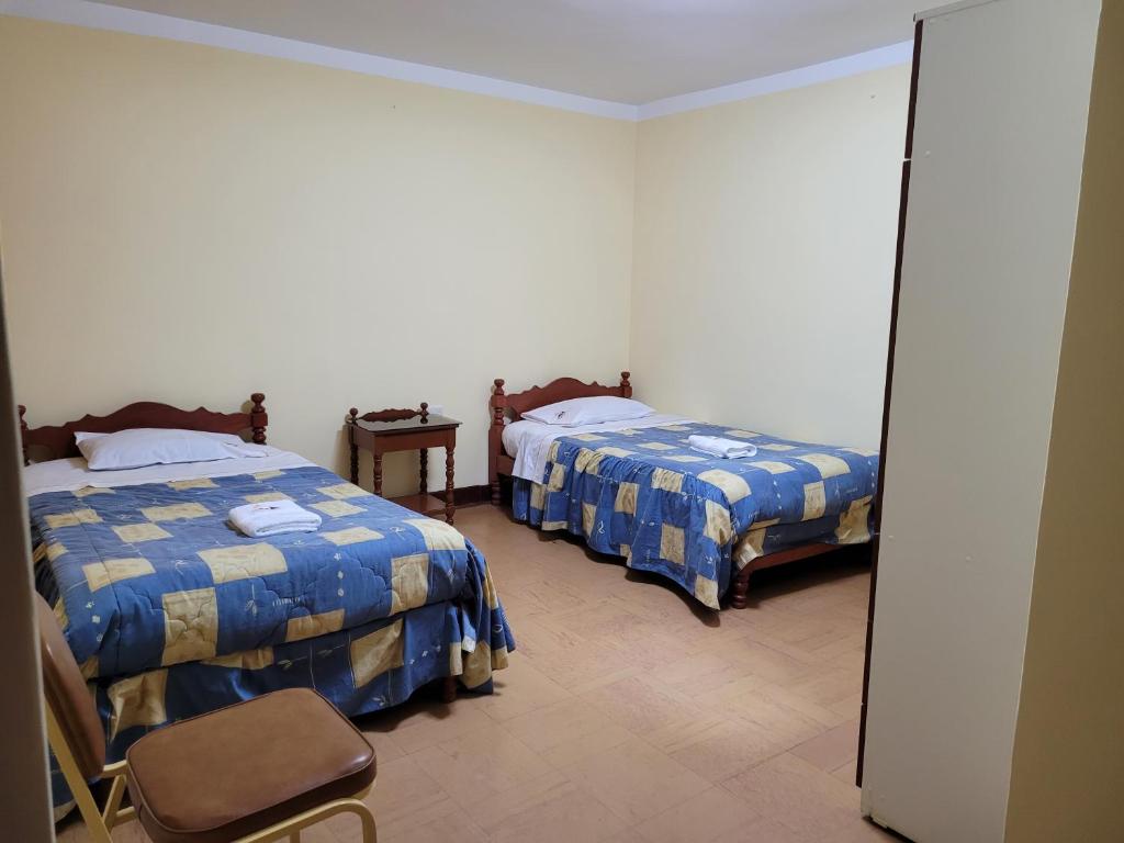 a hotel room with two beds and a mirror at BACKPaCKERS & BACKPaCKERS in Trujillo
