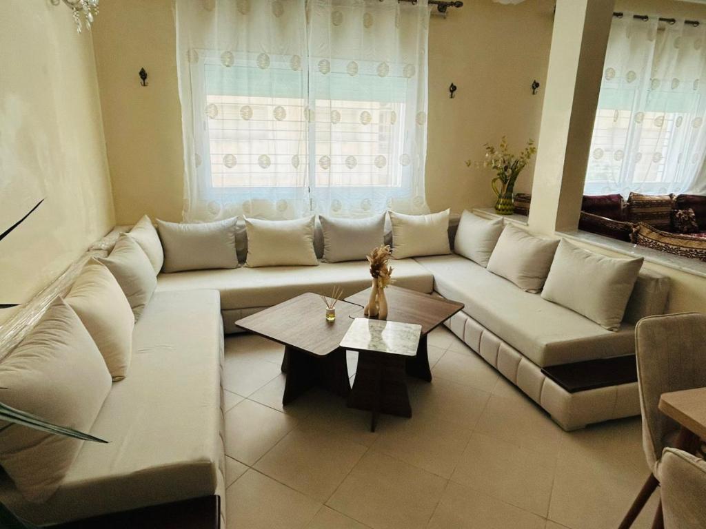 a living room with a white couch and a table at Fès Medina Escape Apartment in Fez