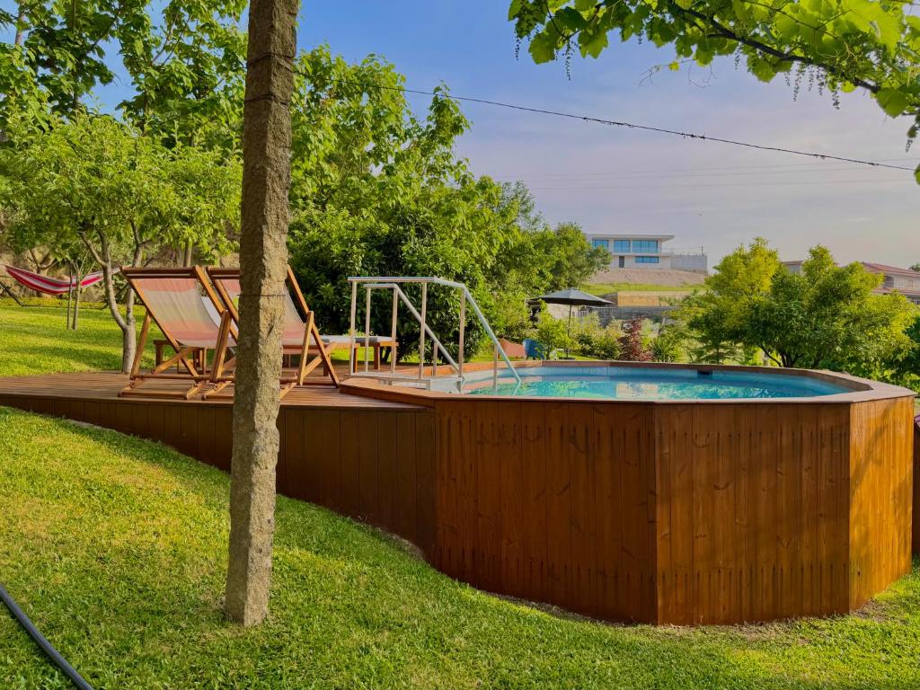 a swimming pool with a chair and a swing at Quintinha da Oliveira in Marco de Canavezes