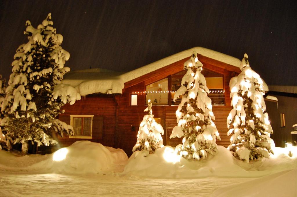 a house with snow covered trees in front of it at Ferienwohnung Allalinblick in Saas-Fee