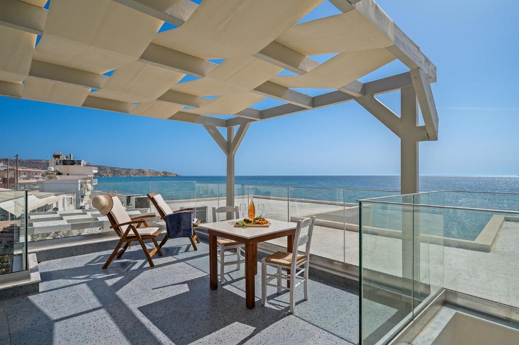 a balcony with a table and chairs and the ocean at Pelagos Home, Liatiko Suite in Kalamaki Heraklion