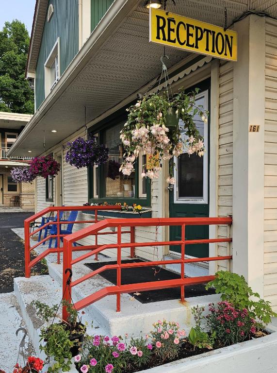 a red bench in front of a building with flowers at Motel Saint-Hilaire in Mont-Saint-Hilaire