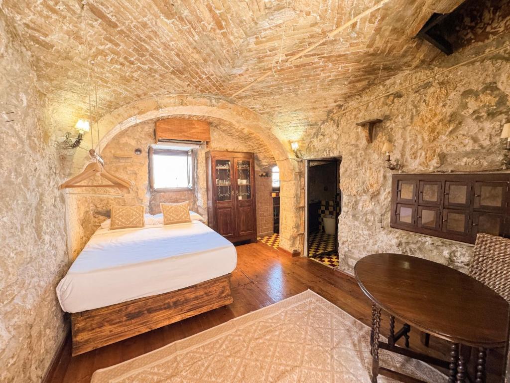 a bedroom with a bed in a stone wall at Kalma Elephant Tower - Medieval Stay with a City View in Cagliari