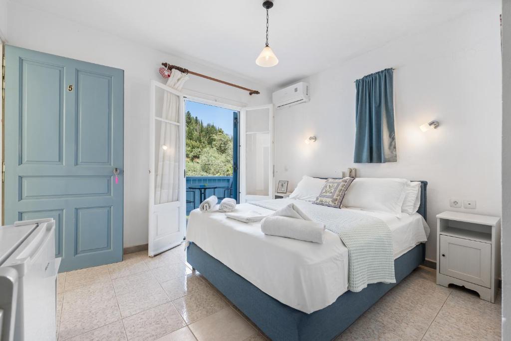a bedroom with a bed and a large window at Hotel Selini in Agios Nikitas
