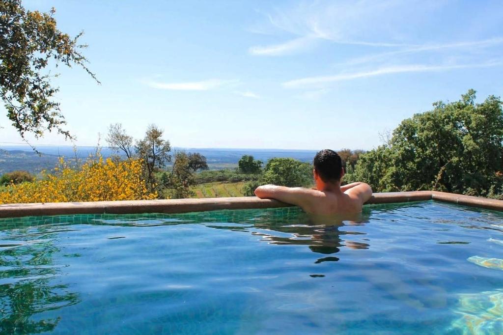 a man in a swimming pool with a view at Quinta do Miradouro in Portalegre
