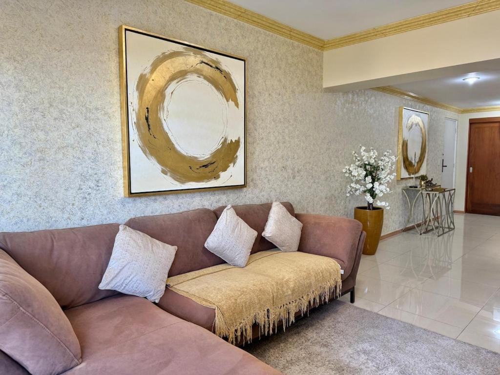 a living room with a brown couch and a painting at Beautiful beachfront space and pool in Mazatlán