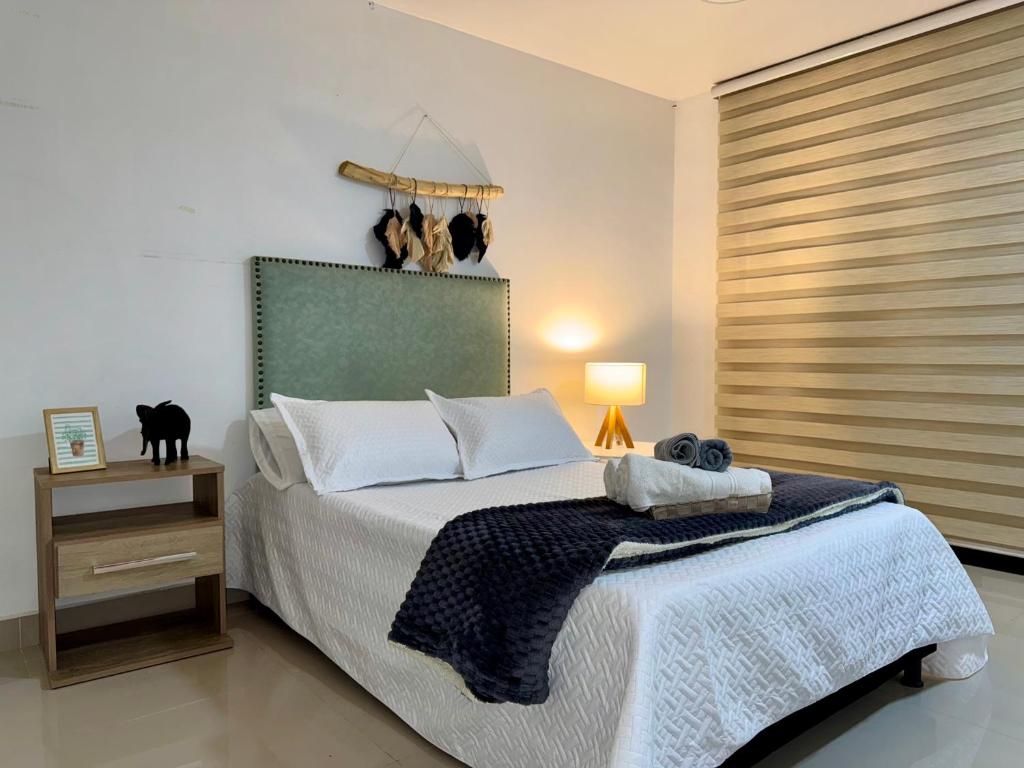 Un dormitorio con una cama con un gato negro. en EasyHouse, en Medellín