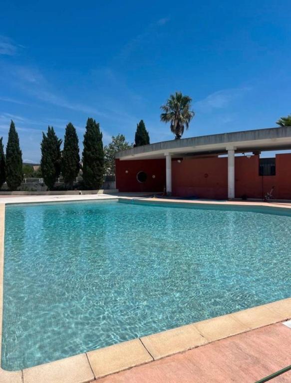 une grande piscine devant un immeuble dans l'établissement Villa climatisé entre Montpellier est Sete proche des plages, à Vic-la-Gardiole
