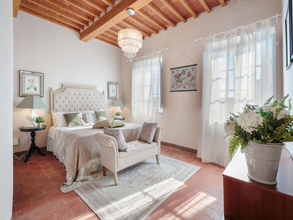 une chambre avec un lit, une chaise et des fenêtres dans l'établissement Villa in Marlia with Pool near Lucca, à Marlia