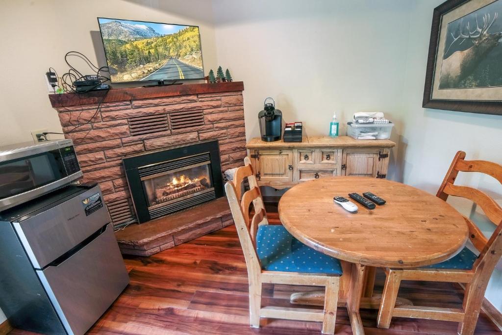 a dining room with a table and a fireplace at Sunnyside Knoll- 10 studio in Estes Park