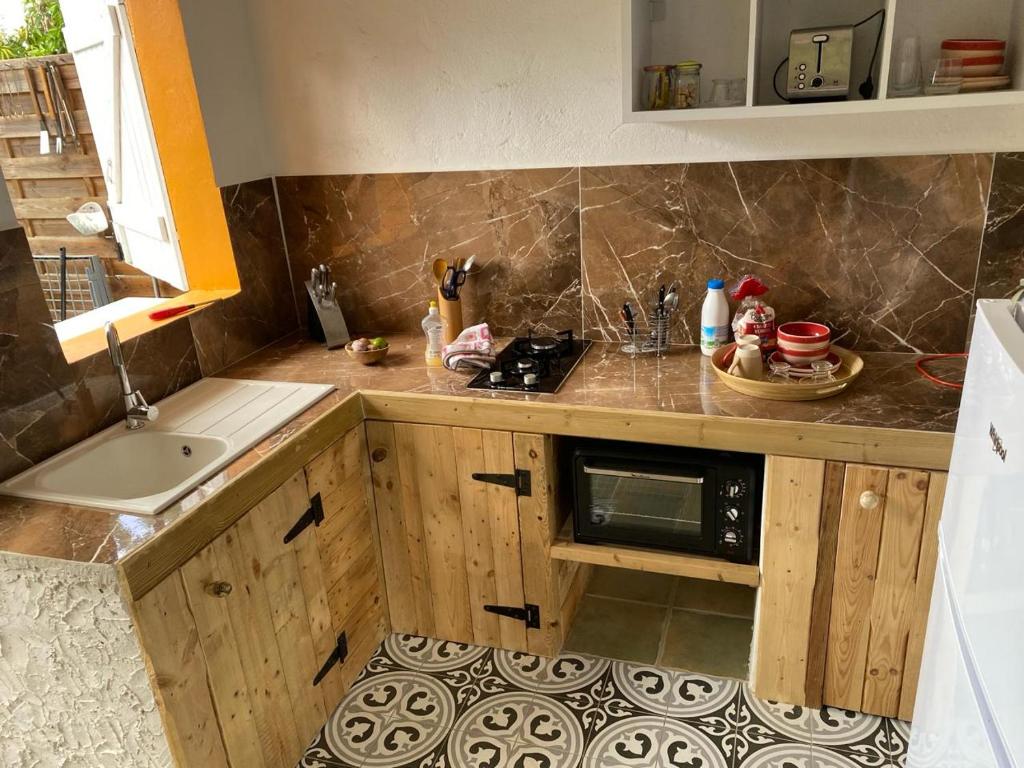 a kitchen with a sink and a microwave at Logement entier, Bungalow ou T2 in Sainte-Rose