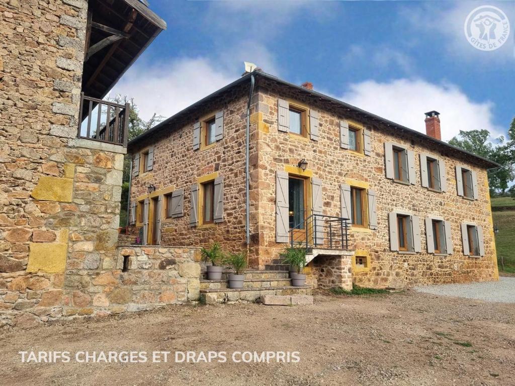 an old brick building with a balcony on it at Gîte de charme avec terrasse, animaux acceptés, confort moderne - FR-1-496-305 in Belmont-de-la-Loire