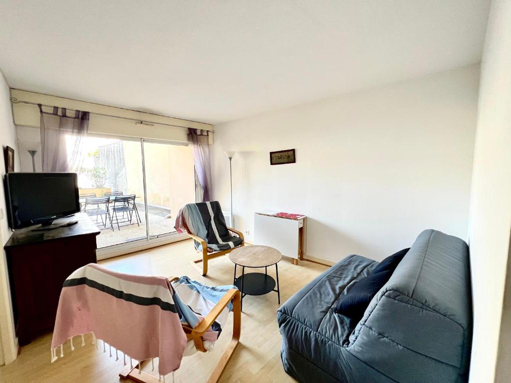 un salon avec un canapé et une télévision dans l'établissement Charmant T2 à Arcachon, Proche Plage et Centre, Parking Privé, TV, WIFI, Terrasse - FR-1-319-506, à Arcachon