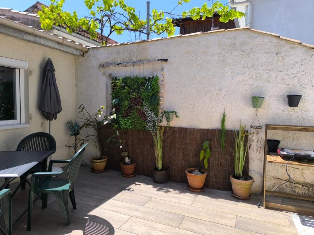 un patio avec des plantes en pot sur le côté d'un bâtiment dans l'établissement Maison T3 avec cour, à deux pas du port de l'Aiguillon, proche commodités et plage - Arcachon - FR-1-319-126, à Arcachon
